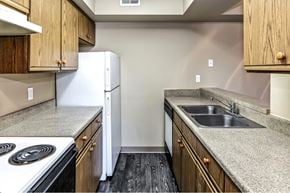 Omaha apartment for rent - a kitchen with granite counter tops and a sink and refrigerator