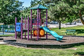 Omaha apartment for rent - a playground with a slide and other toys in a park
