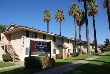 Redlands apartment for rent - A brown sign in front of a building that says Brookside Palms.