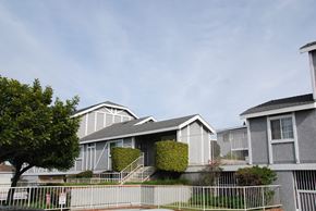 Hawthorne apartment for rent - A row of houses with a white fence in front.