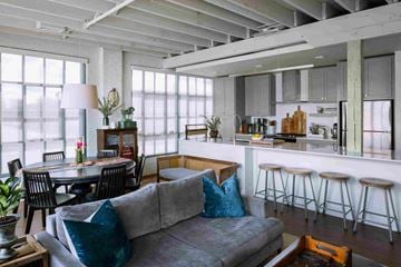 Cleveland apartment for rent - A living room with a grey couch and a dining table with chairs.