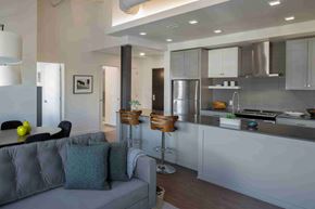 Cleveland apartment for rent - A modern kitchen with a grey couch and bar stools.