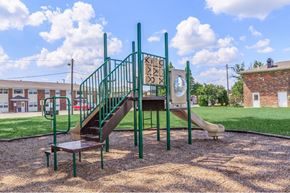 Evansville townhouse for rent - a playground with a slide and stairs in front of a building