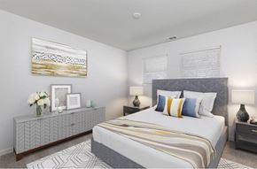 Evansville townhouse for rent - A bedroom with a large bed and a grey and white patterned dresser.