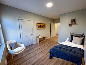 Portland apartment for rent - A bedroom with a bed, chair, and artwork.