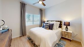 Albuquerque apartment for rent - A bedroom with a large bed, a nightstand, and a ceiling fan.