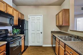 Conway apartment for rent - A kitchen with wooden cabinets and a black stove top oven.