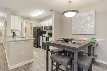 Our model home has an open floor plan with a dining room table and a kitchen