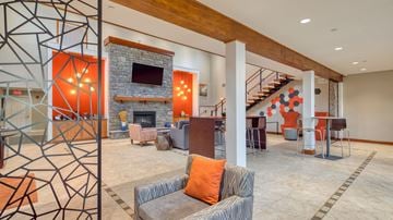 Blacksburg apartment for rent - A modern living room with a grey couch and a stone fireplace.