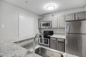 Raleigh apartment for rent - a kitchen with granite counter tops and stainless steel appliances at Midtown Crossing in Raleigh, North Carolina 27609