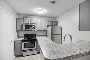 Raleigh apartment for rent - a kitchen with granite counter tops and stainless steel appliances at Midtown Crossing in Raleigh, NC