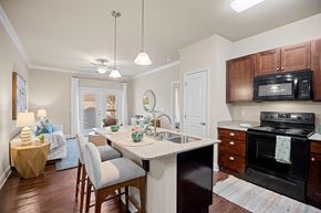 Clayton apartment for rent - A kitchen with a black stove and wooden cabinets.