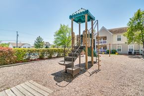 Henrico apartment for rent - A playground with a green roofed slide and a wooden platform.