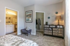 Raleigh apartment for rent - A bedroom with a grey carpet and a grey bed.