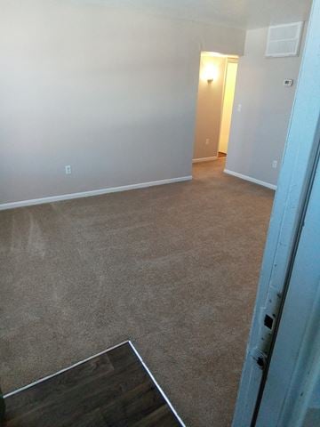 Poquoson apartment for rent - A room with a carpeted floor and a doorway leading to another room.