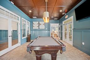 Clayton apartment for rent - A pool table is in the middle of a room with a wooden ceiling.