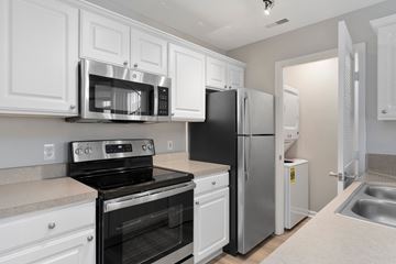 Columbus apartment for rent - A kitchen with white cabinets and black appliances.