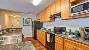Blacksburg apartment for rent - A kitchen with wooden cabinets and a black refrigerator.