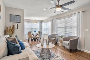 Myrtle Beach apartment for rent - A living room with a beige sofa, a coffee table, and a ceiling fan.