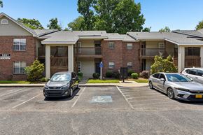 Rock Hill apartment for rent - A black car is parked in a parking lot in front of a brick apartment building.