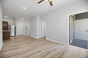 Charlotte apartment for rent - A spacious room with a ceiling fan and lighting.