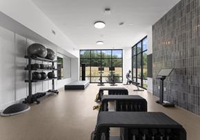 Clover apartment for rent - A gym with black and white equipment and a glass wall.