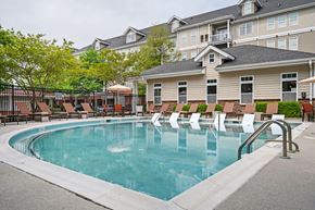 Chesapeake apartment for rent - A large swimming pool with lounge chairs and a building in the background.