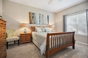 Raleigh apartment for rent - a bedroom with a bed and a chair and a window