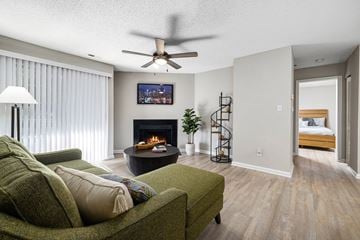 Raleigh apartment for rent - A living room with a green couch and a fireplace.