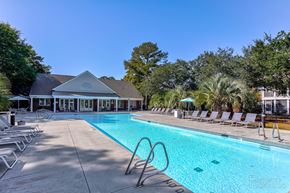 Wilmington apartment for rent - a swimming pool with chairs and a building in the backgroundat Barclay Place Apartments, Wilmington