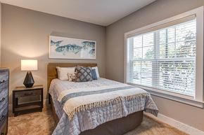Wilmington apartment for rent - a bedroom with a bed and a large window at Barclay Place Apartments, North Carolina