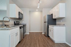 Columbus apartment for rent - A kitchen with white cabinets and a black refrigerator.