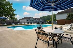 Marysville apartment for rent - A pool with chairs and an umbrella in the foreground.