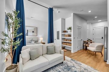 Newport News apartment for rent - A living room with a white couch and a potted plant.