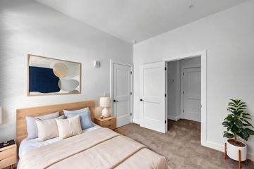 Newport News apartment for rent - A bedroom with a large bed and a painting on the wall.