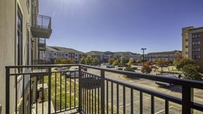 Newport News apartment for rent - A sunny day in a residential area with apartment buildings and cars parked in the driveways at Aviator Lofts, Newport News, VA 23602