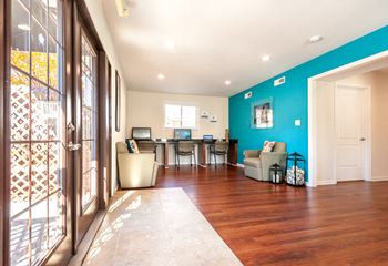 The living room and kitchen of a house with a blue wall