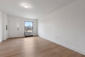 Charlotte apartment for rent - A large empty room with a view of a building outside the window.