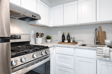 Dundalk apartment for rent - A modern kitchen with a stainless steel stove and white cabinets.
