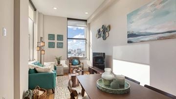 Richmond apartment for rent - A living room with a green chair and a painting on the wall.