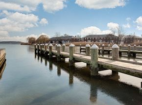 Dundalk apartment for rent - A wooden pier extends into a calm body of water with a building in the background.