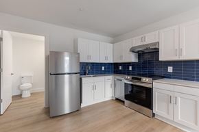 Charlotte apartment for rent - A kitchen with a stainless steel refrigerator, oven, and cabinets.
