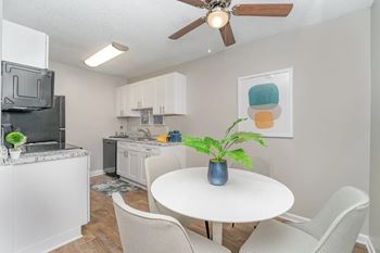 A kitchen and dining room with a table and chairs