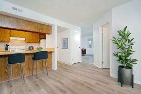 Dublin townhouse for rent - A kitchen with wooden cabinets and a bar area with two stools.