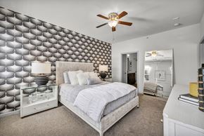 Columbus apartment for rent - A bedroom with a bed, dresser, and a ceiling fan.