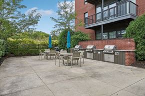 Dublin apartment for rent - A patio with a table and chairs is surrounded by a brick building and trees.