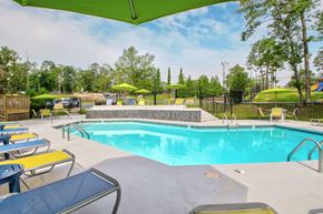 Little Rock apartment for rent - our resort style swimming pool is filled with lounge chairs and umbrellas