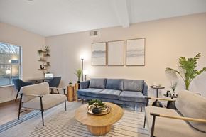 Rock Hill apartment for rent - A living room with a grey sofa, a wooden coffee table, and a blue chair.