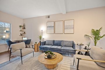 Rock Hill apartment for rent - A living room with a grey sofa, a wooden coffee table, and a blue chair.