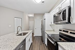 Raleigh apartment for rent - A kitchen with white cabinets and granite countertops.